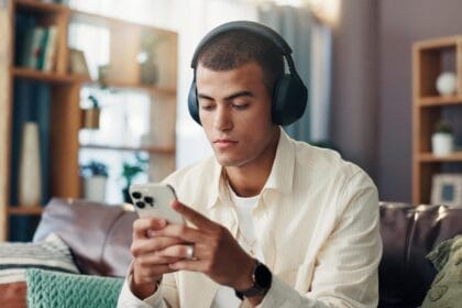 Hombre jugando con su teléfono usando auriculares